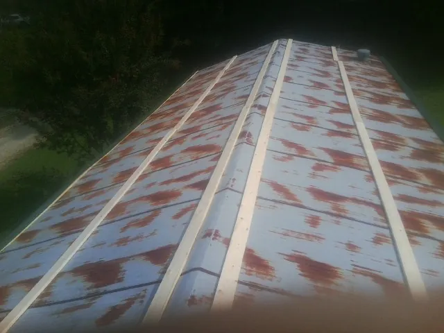 Rusted metal roof panels with new wood purlins before replacement — Storm Damage Roof Repair in Canehill by Roofing Brothers