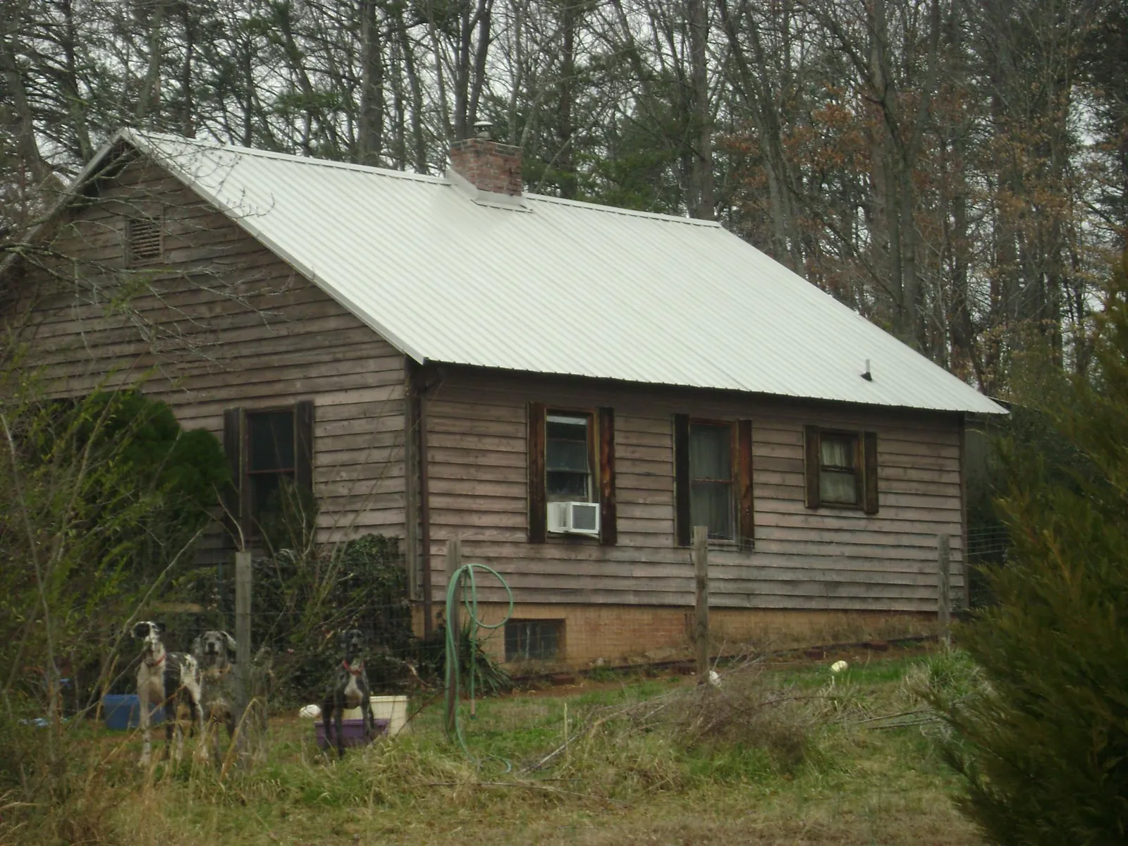 White metal roof on an old wood sided farmhouse, from a Metal Roof Installation job in Canehill